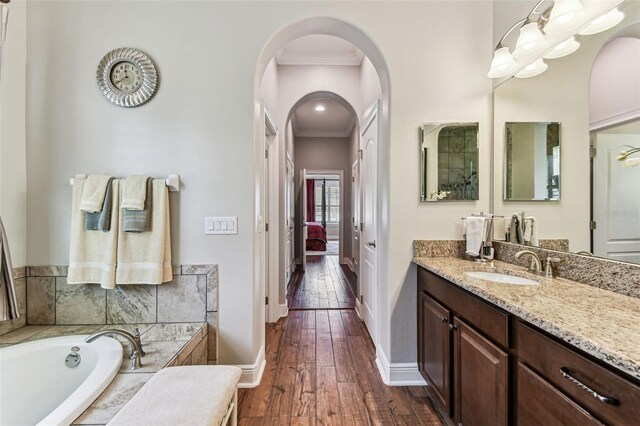 4133 Foxhound Dr, Clermont, FL 34711 - full bath featuring vanity, a bath, wood-type flooring, crown molding, and ensuite bathroom