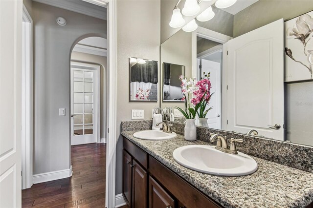 4133 Foxhound Dr, Clermont, FL 34711 - full bathroom featuring wood finished floors, double vanity, and a chandelier