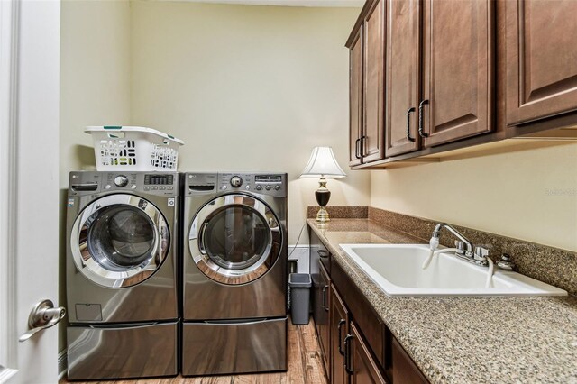4133 Foxhound Dr, Clermont, FL 34711 - laundry area featuring independent washer and dryer, cabinet space, and light wood-style floors
