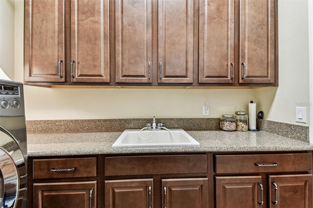 4133 Foxhound Dr, Clermont, FL 34711 - kitchen featuring dark brown cabinets and estacked washer and dryer
