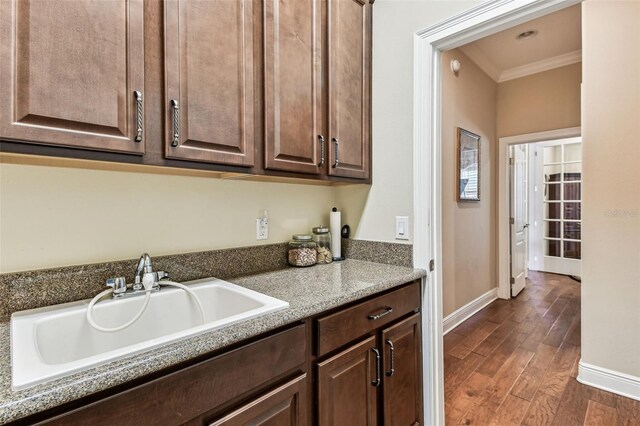 4133 Foxhound Dr, Clermont, FL 34711 - kitchen featuring ornamental molding, dark brown cabinetry, and dark wood-style floors