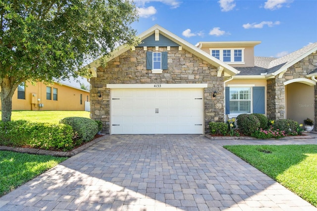 4133 Foxhound Dr, Clermont, FL 34711 - craftsman house with stone siding, decorative driveway, a garage, a front yard, and stucco siding