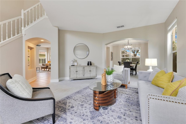 4993 Hook Hollow Cir, Orlando, FL 32837 - living room with arched walkways, a chandelier, carpet floors, and baseboards