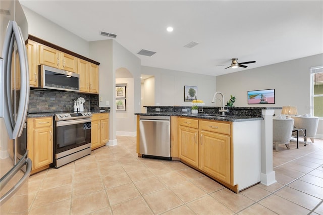 4993 Hook Hollow Cir, Orlando, FL 32837 - kitchen featuring stainless steel appliances, a sink, light brown cabinets, backsplash, and ceiling fan