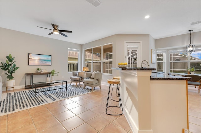 4993 Hook Hollow Cir, Orlando, FL 32837 - kitchen featuring dark stone counters, ceiling fan, light tile patterned floors, healthy amount of natural light, and recessed lighting