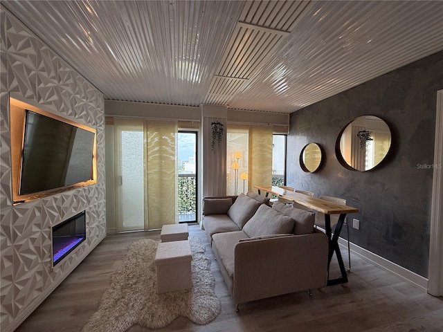 6165 Carrier Dr Unit 1801, Orlando, FL 32819 - living area with wood finished floors, a stone fireplace, and baseboards