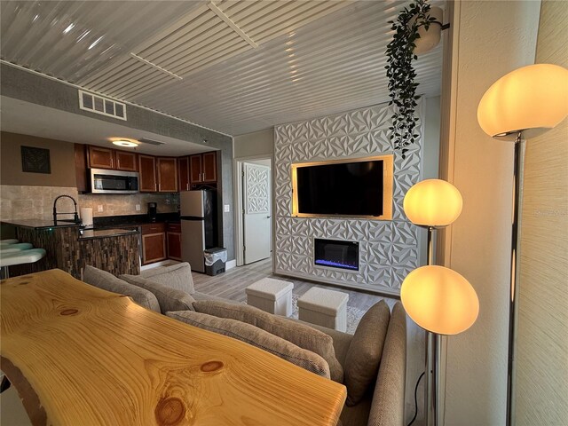 6165 Carrier Dr Unit 1801, Orlando, FL 32819 - living area with light wood-type flooring and a glass covered fireplace