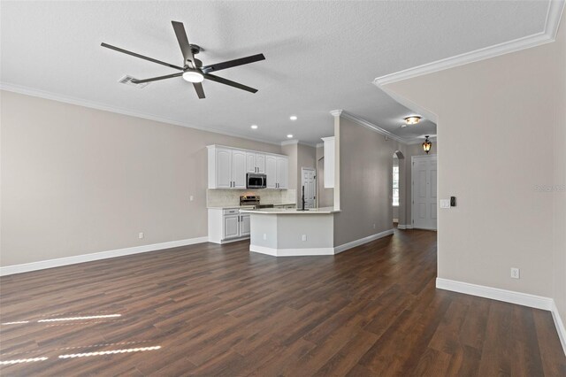 461 Black Knight Way, Longwood, FL 32779 - unfurnished living room featuring ceiling fan, crown molding, arched walkways, baseboards, and dark wood-style flooring