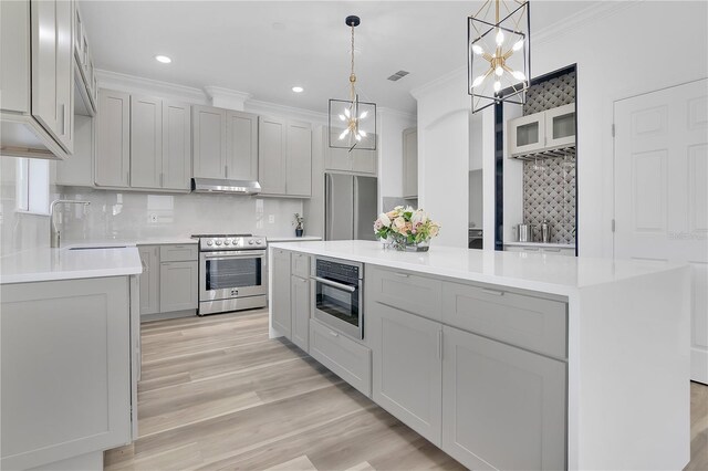 17657 Windy Pine St, Montverde, FL 34756 - kitchen featuring stainless steel appliances, decorative backsplash, gray cabinets, a chandelier, and crown molding