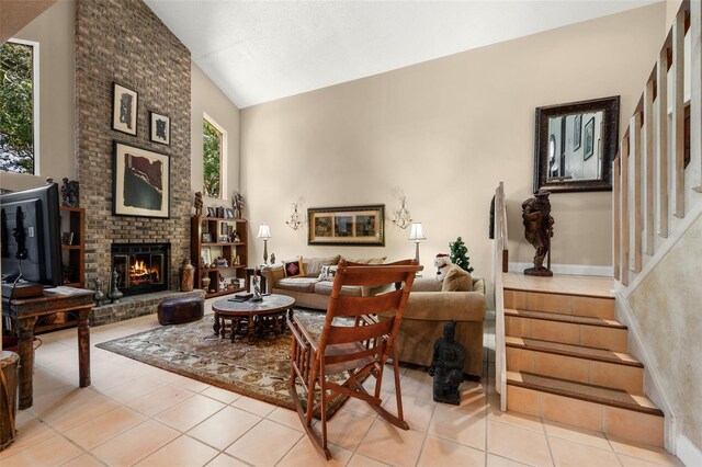 6460 Parson Brown Dr, Orlando, FL 32819 - living room with light tile patterned floors, vaulted ceiling, stairs, and a fireplace