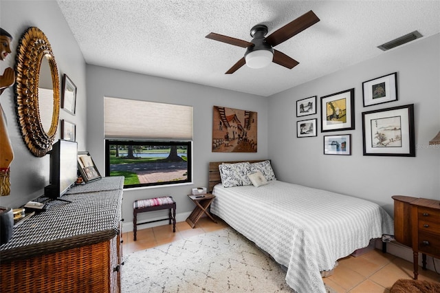 6460 Parson Brown Dr, Orlando, FL 32819 - bedroom with light tile patterned floors, a textured ceiling, and a ceiling fan