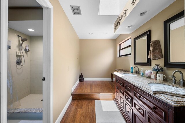 6460 Parson Brown Dr, Orlando, FL 32819 - bathroom with wood finished floors, double vanity, baseboards, tiled shower, and recessed lighting