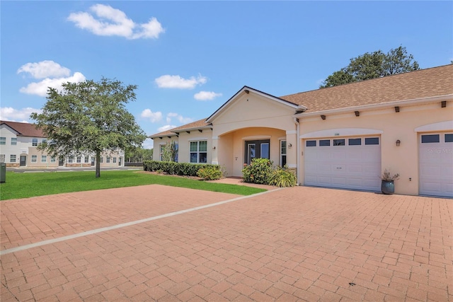 2100 Shantiniketan Blvd, Tavares, FL 32778 - view of front of house with stucco siding, a front yard, decorative driveway, and a garage