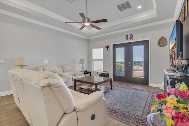 2100 Shantiniketan Blvd, Tavares, FL 32778 - living area featuring a tray ceiling, french doors, a ceiling fan, crown molding, and wood finished floors