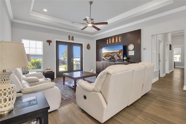 2100 Shantiniketan Blvd, Tavares, FL 32778 - living room featuring a tray ceiling, healthy amount of natural light, ornamental molding, a ceiling fan, and wood finished floors