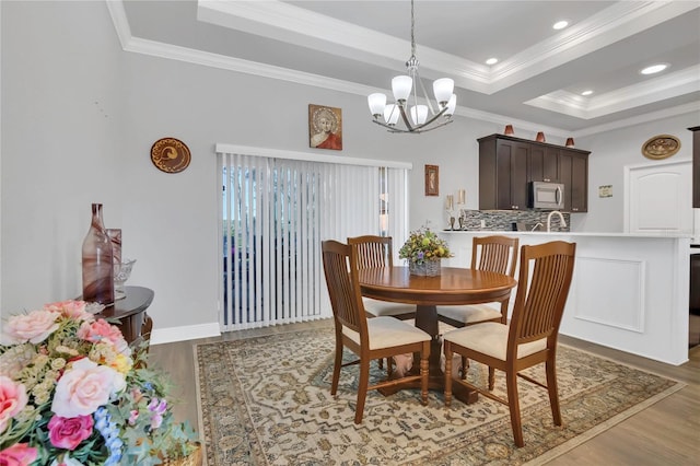 2100 Shantiniketan Blvd, Tavares, FL 32778 - dining area featuring wood finished floors, a chandelier, crown molding, a raised ceiling, and recessed lighting