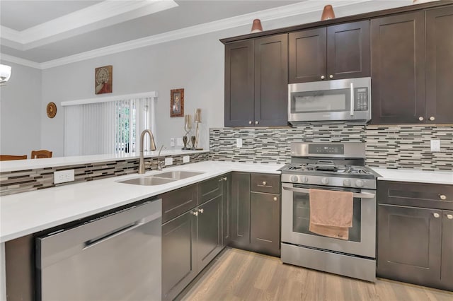 2100 Shantiniketan Blvd, Tavares, FL 32778 - kitchen featuring stainless steel appliances, a sink, dark brown cabinets, light countertops, and light wood-style floors