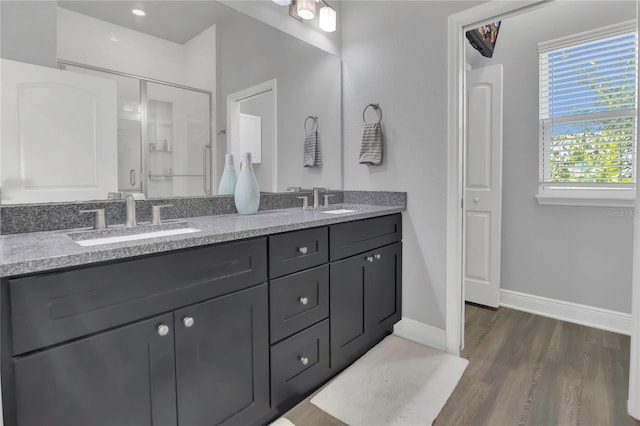 2100 Shantiniketan Blvd, Tavares, FL 32778 - bathroom featuring wood finished floors, double vanity, a shower stall, and baseboards