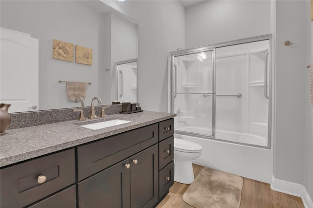 2100 Shantiniketan Blvd, Tavares, FL 32778 - bathroom with vanity, toilet, wood finished floors, and enclosed tub / shower combo