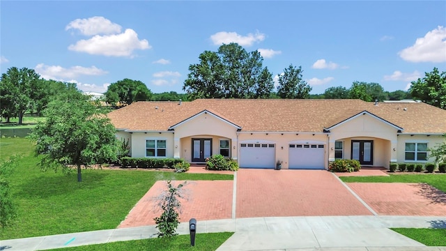 2100 Shantiniketan Blvd, Tavares, FL 32778 - mediterranean / spanish-style house featuring french doors, decorative driveway, a garage, a front yard, and stucco siding