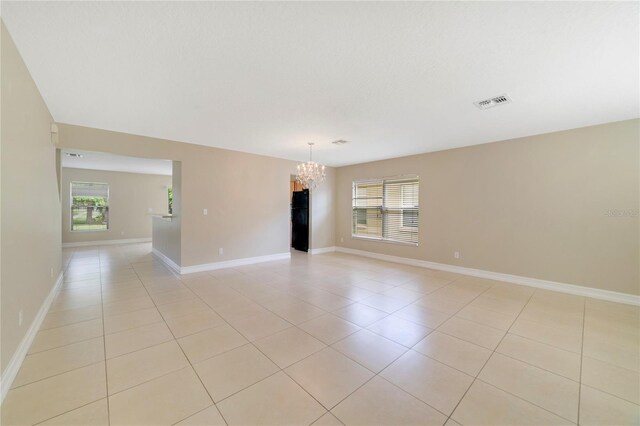 806 Sterling Spring Rd, Orlando, FL 32828 - empty room with a chandelier, light tile patterned floors, and baseboards