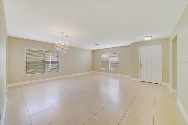 806 Sterling Spring Rd, Orlando, FL 32828 - empty room with a chandelier, light tile patterned floors, and baseboards