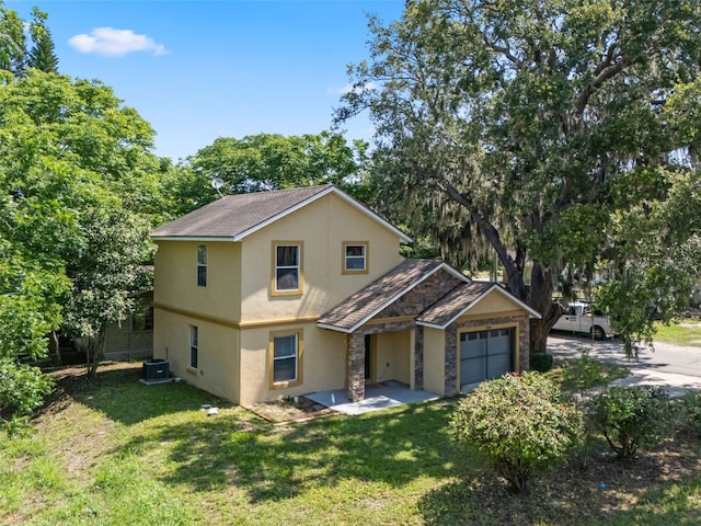 500 W Oakland Ave, Oakland, FL 34760 - view of front of home featuring stucco siding, central AC unit, an attached garage, and a front lawn