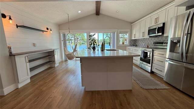 6428 Lynn Rd, Orlando, FL 32810 - kitchen with appliances with stainless steel finishes, a sink, open shelves, white cabinetry, and wood walls
