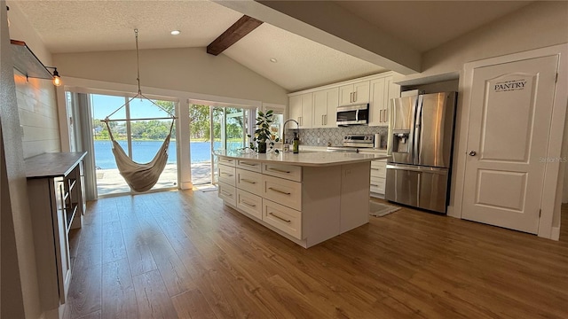 6428 Lynn Rd, Orlando, FL 32810 - kitchen with appliances with stainless steel finishes, beam ceiling, dark wood-style flooring, decorative backsplash, and white cabinetry