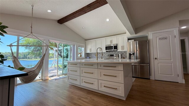 6428 Lynn Rd, Orlando, FL 32810 - kitchen featuring stainless steel appliances, light countertops, dark wood-style floors, decorative backsplash, and white cabinets
