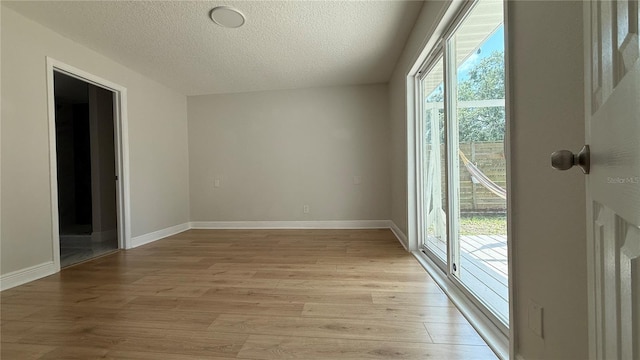 6428 Lynn Rd, Orlando, FL 32810 - unfurnished room with light wood-type flooring, plenty of natural light, a textured ceiling, and baseboards