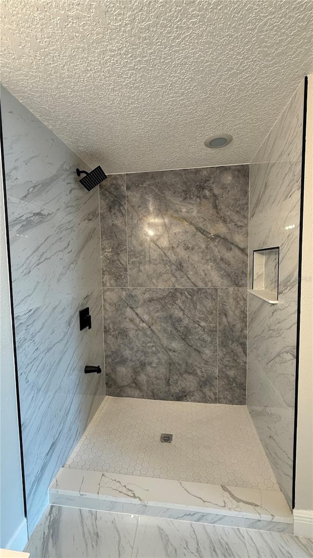 6428 Lynn Rd, Orlando, FL 32810 - bathroom with marble look tile flooring, a marble finish shower, and a textured ceiling