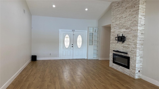 6428 Lynn Rd, Orlando, FL 32810 - foyer entrance featuring wood finished floors, baseboards, high vaulted ceiling, and a stone fireplace