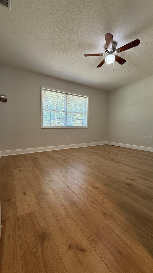 6428 Lynn Rd, Orlando, FL 32810 - spare room with a textured ceiling, wood finished floors, ceiling fan, and baseboards
