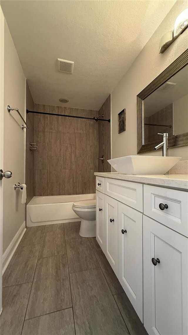 6428 Lynn Rd, Orlando, FL 32810 - bathroom with vanity, toilet, bathing tub / shower combination, wood finished floors, and a textured ceiling