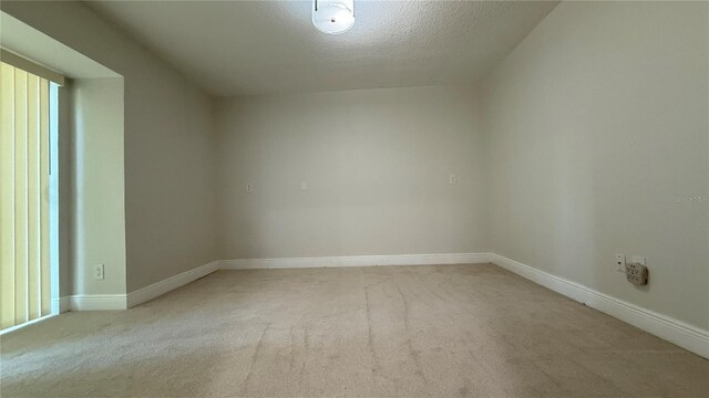 6428 Lynn Rd, Orlando, FL 32810 - empty room featuring light carpet, baseboards, and a textured ceiling
