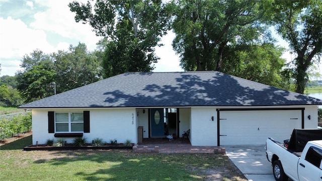 6428 Lynn Rd, Orlando, FL 32810 - view of front of home featuring roof with shingles, a garage, a porch, stucco siding, and a front lawn