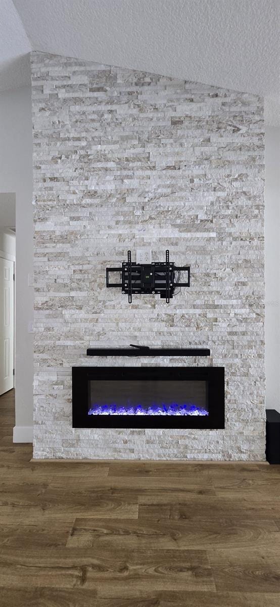 6428 Lynn Rd, Orlando, FL 32810 - detailed view of a stone fireplace, wood finished floors, a textured ceiling, and baseboards