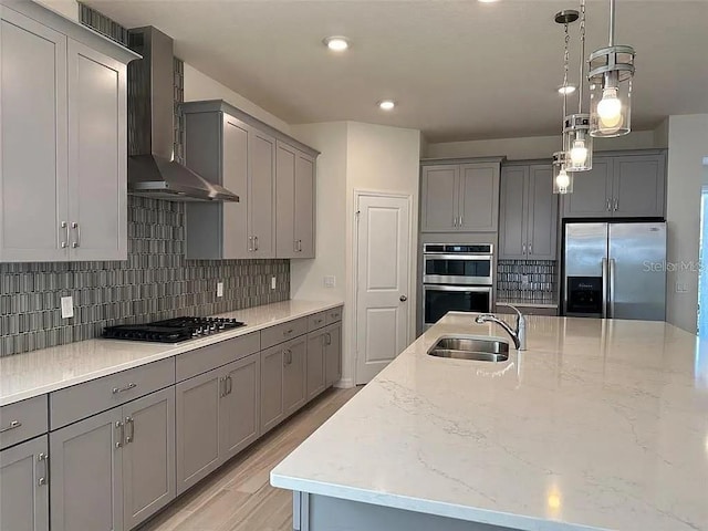 605 Big Pine Ave, Minneola, FL 34715 - kitchen with appliances with stainless steel finishes, gray cabinetry, wall chimney range hood, a sink, and light stone counters