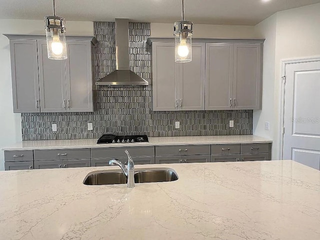 605 Big Pine Ave, Minneola, FL 34715 - kitchen featuring gray cabinetry, a sink, wall chimney range hood, black cooktop, and decorative backsplash