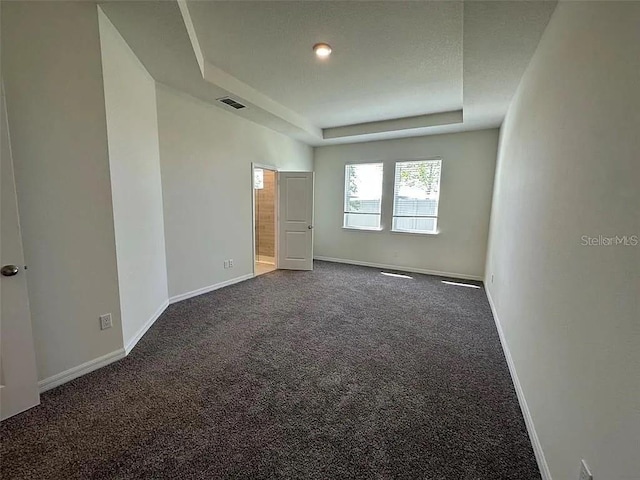605 Big Pine Ave, Minneola, FL 34715 - unfurnished bedroom featuring dark colored carpet, a tray ceiling, and baseboards
