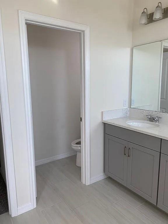 605 Big Pine Ave, Minneola, FL 34715 - bathroom featuring vanity, toilet, and baseboards