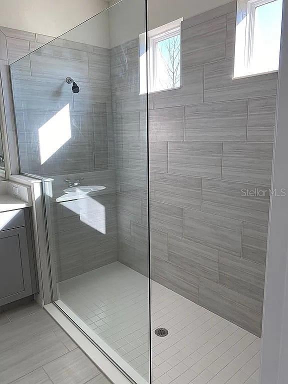 605 Big Pine Ave, Minneola, FL 34715 - bathroom featuring tiled shower and tile patterned flooring