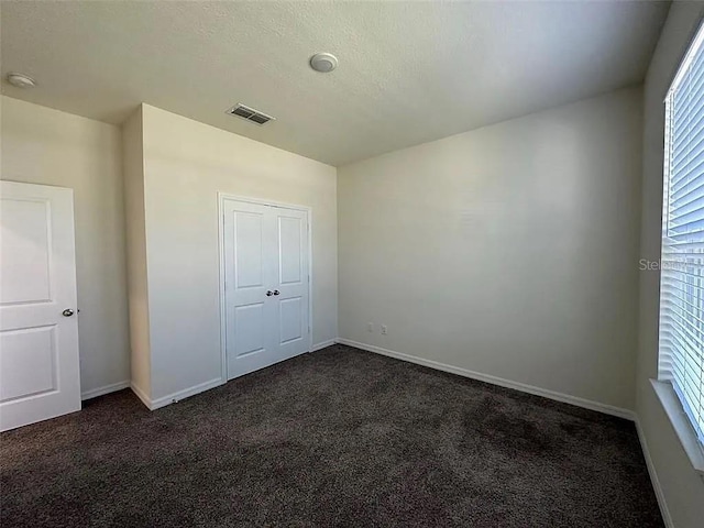 605 Big Pine Ave, Minneola, FL 34715 - unfurnished bedroom featuring dark colored carpet and baseboards