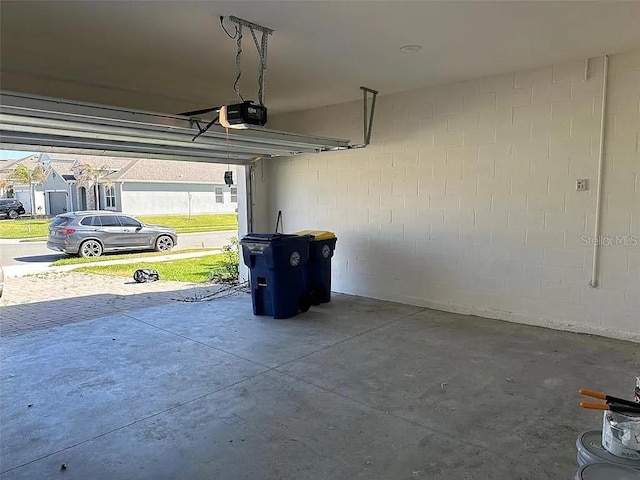 605 Big Pine Ave, Minneola, FL 34715 - garage featuring a garage door opener and concrete block wall