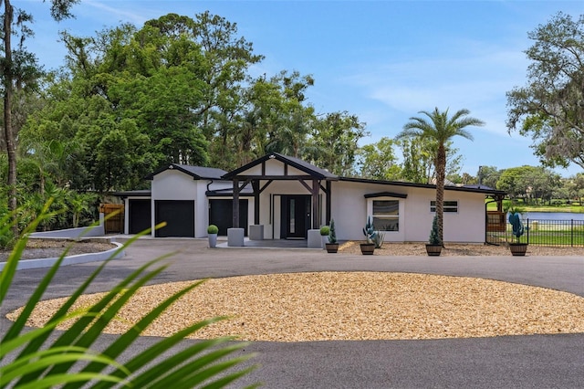 1700 Lake Markham Rd, Sanford, FL 32771 - view of front of house with an attached garage, asphalt driveway, and stucco siding