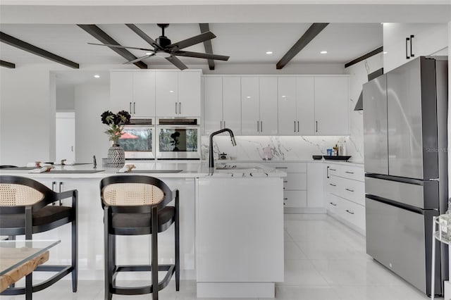 1700 Lake Markham Rd, Sanford, FL 32771 - kitchen featuring stainless steel appliances, beamed ceiling, light countertops, ceiling fan, and white cabinets