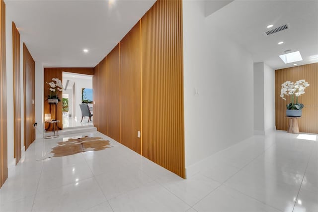 1700 Lake Markham Rd, Sanford, FL 32771 - hall featuring an accent wall, a skylight, wood walls, recessed lighting, and tile patterned flooring
