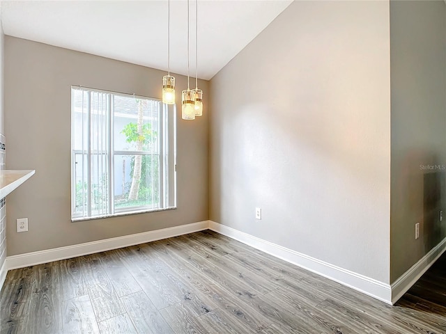 2124 Fish Eagle St, Clermont, FL 34714 - unfurnished dining area featuring wood finished floors, lofted ceiling, baseboards, and a chandelier