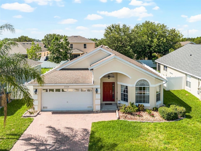 2729 Stanwood Dr, Kissimmee, FL 34743 - view of front of property with an attached garage, decorative driveway, a front lawn, and stucco siding